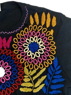 Beautifully hand embroidered shirts made in Mexico by our artisan partners who are expert embroiderers. Each shirt will come in the color you pick with the embroidery slightly varying in colors. This shirt will be a staple in your wardrobe / store!Runs SMALL. Order 1-2 sizes larger. Large & XL are the best sellers. Black Cotton Tops With Machine Embroidery, Custom Embroidered Long Sleeve T-shirt, Traditional Black Crew Neck Top, Short Sleeve Cotton Embroidered Top With Tonal Embroidery, Short Sleeve Cotton Top With Tonal Embroidery, Cotton Embroidered Top With Tonal Embroidery And Short Sleeves, Traditional Crew Neck Cotton Top, Traditional Cotton Crew Neck Top, Black Cotton Top With Geometric Embroidery