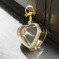 Gold Locket Necklace (mini size) Our mini gold lockets are the best way to store life's little treasures and wear them around your neck for eternity.  So easy to open and double-sided to contain two special photographs or a cherished memory item that can be viewed from both sides.  The lockets have a 5mm internal gap so you can even store crystals inside or some pills (daily medication if you are going on a trip, perhaps?). This beautiful Victorian style hand-crafted locket pendant holds a small memorial or keepsake for your loved one to cherish.  This is the perfect memorial gift to store the ashes of a late pet dog or cat, or maybe even some of their fur inside. To open and close the locket, simply screw or unscrew the silver nut.  All lockets in this section are approximately 1.5 inches Gold Necklaces With Detachable Pendant For Keepsake, Gold Charms Locket Necklace Keepsake, Brass Locket Necklace With Charms For Keepsake, Gold Spiritual Jewelry For Keepsake, Gold Heart Locket Necklace Spiritual Style, Gold Heart-shaped Spiritual Locket Necklace, Spiritual Gold Heart Locket Necklace, Gold Heart Charm Locket Necklace, Gold Round Locket Necklace With Heart Charm