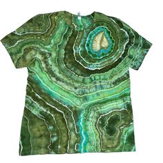 This listing is for a MADE-TO-ORDER fern tee. These shirts are one of a kind and feature fern prints that are made with REAL Missouri fern fronds and a special solar dyeing process. These prints are surrounded by a tie-dye geode pattern in earthy green tones. I use high-quality dyes for long-lasting color! **Each fern tee is unique so the green tones will vary, please see photos for examples of past work. We use Bella & Canvas shirts that are made from super soft light-weight cotton and have a s Green Bohemian Crew Neck T-shirt, Green Casual Tops With Batik Print, Bohemian Hand Dyed Crew Neck T-shirt, Casual Green Batik Print Top, Green Batik Print Top For Summer, Green Cotton Tops With Batik Print, Green Cotton Batik Print Tops, Bohemian Green Relaxed Fit T-shirt, Green Nature-inspired Cotton T-shirt