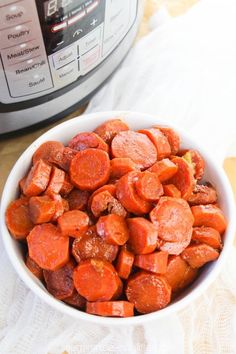 a white bowl filled with cooked carrots next to an instant pressure cooker