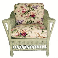 a wicker chair with flowers on the back and seat cushion is upholstered