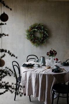 the table is set for two with plates and cups on it, surrounded by greenery