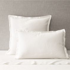 two white pillows sitting on top of a bed