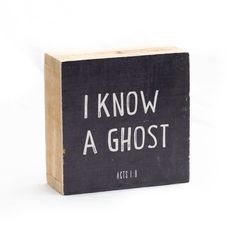 a wooden block with the words i know a ghost written in white ink on it