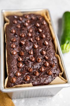 a chocolate cake in a pan on top of a counter next to a green pepper