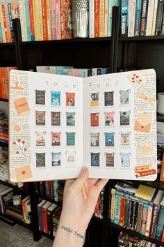 a person holding up an open book in front of a bookshelf full of books