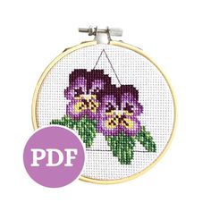 a cross stitch pattern with purple flowers on it