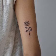 a woman's arm with a rose tattoo on the left side of her arm