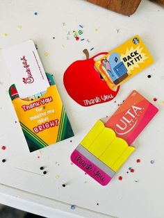 some school supplies are laying out on a white table with confetti and sprinkles