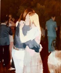 two people hugging each other while standing in front of a group of people at a party