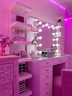 a pink vanity with lighted lights in a room