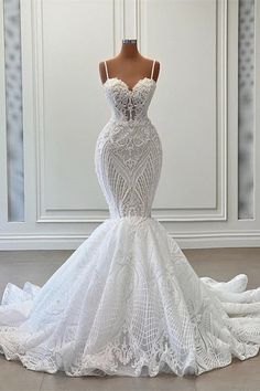 a white wedding dress on a mannequin in front of a wall and floor