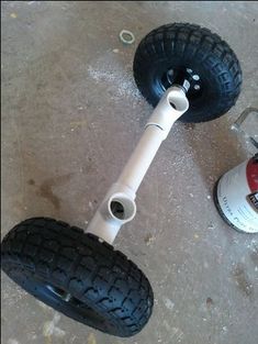 two white wheels and one black wheel on the floor next to a can of beer