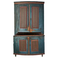 an old blue cabinet with two doors on the front and one door open to reveal something