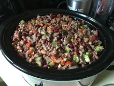 a crock pot filled with beans and veggies