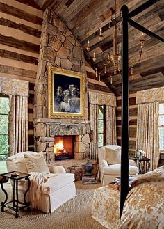 a living room filled with furniture and a fire place under a painting on the wall