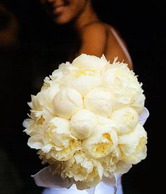 a bride holding a bouquet of white flowers