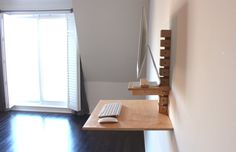 a desk with a keyboard, mouse and monitor on it in front of a window