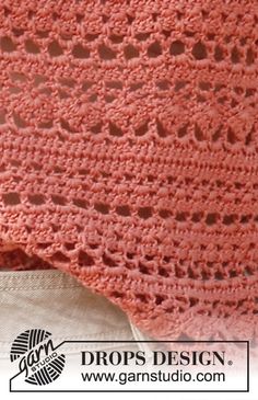 a pink crocheted blanket sitting on top of a table