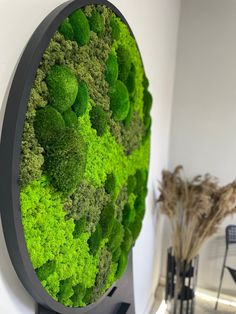 a green wall mounted to the side of a white wall next to a black table