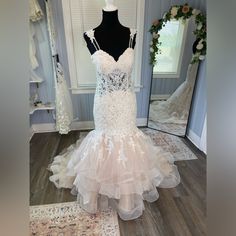 a wedding dress on display in front of a mirror