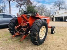 an orange tractor parked in front of a house