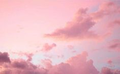 an airplane is flying in the sky at sunset or dawn with clouds and pink hues