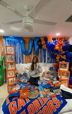 a woman standing in front of a bed with balloons and decorations