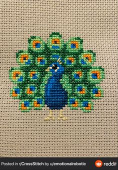 a cross stitch peacock is shown on a white background