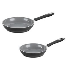 two frying pans sitting side by side on a white surface