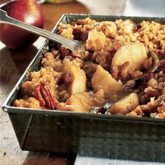 a metal pan filled with food next to an apple