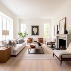 a living room filled with furniture and a fire place in front of a window on top of a hard wood floor