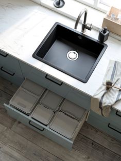 a kitchen sink sitting under a window next to a counter