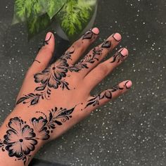 a woman's hand with henna tattoos on it