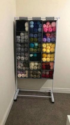 a rack filled with lots of different colored balls of yarn