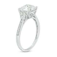 an oval cut diamond engagement ring with side stones on the band and shoulders, set in 18k white gold