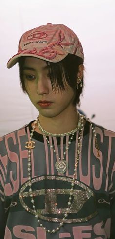 a young man wearing a hat and beaded necklace