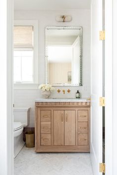 a bathroom with a sink, mirror and toilet