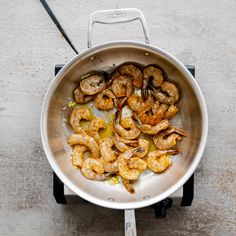 shrimp being cooked in a frying pan with tongs