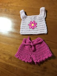 two crocheted items sitting on top of a wooden table