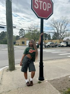 a woman standing next to a stop sign