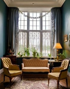 a living room filled with furniture next to a window covered in curtains and drapes