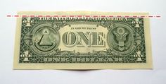 the one dollar bill is in a clear plastic case on a white surface with black writing