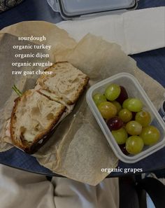 a sandwich and grapes in a plastic container