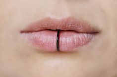 a woman's lip with a thin black ring on the tip of her lip