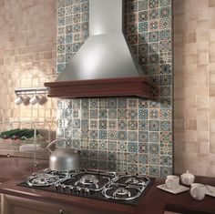 a stove top oven sitting inside of a kitchen next to a wall mounted range hood