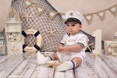 a baby in a sailor outfit sitting on the floor