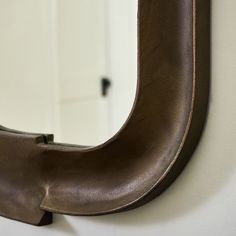 a close up of a mirror on a wall with a white door in the background