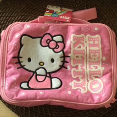 a pink hello kitty lunch bag sitting on top of a table