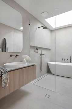 a bathroom with a tub, sink, and shower in the middle of it's walls